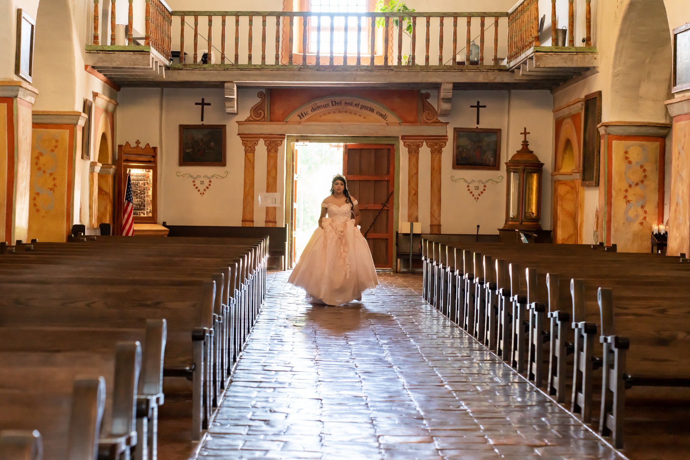 Amanda's daughter's quincinera mission aisle backlit doorway