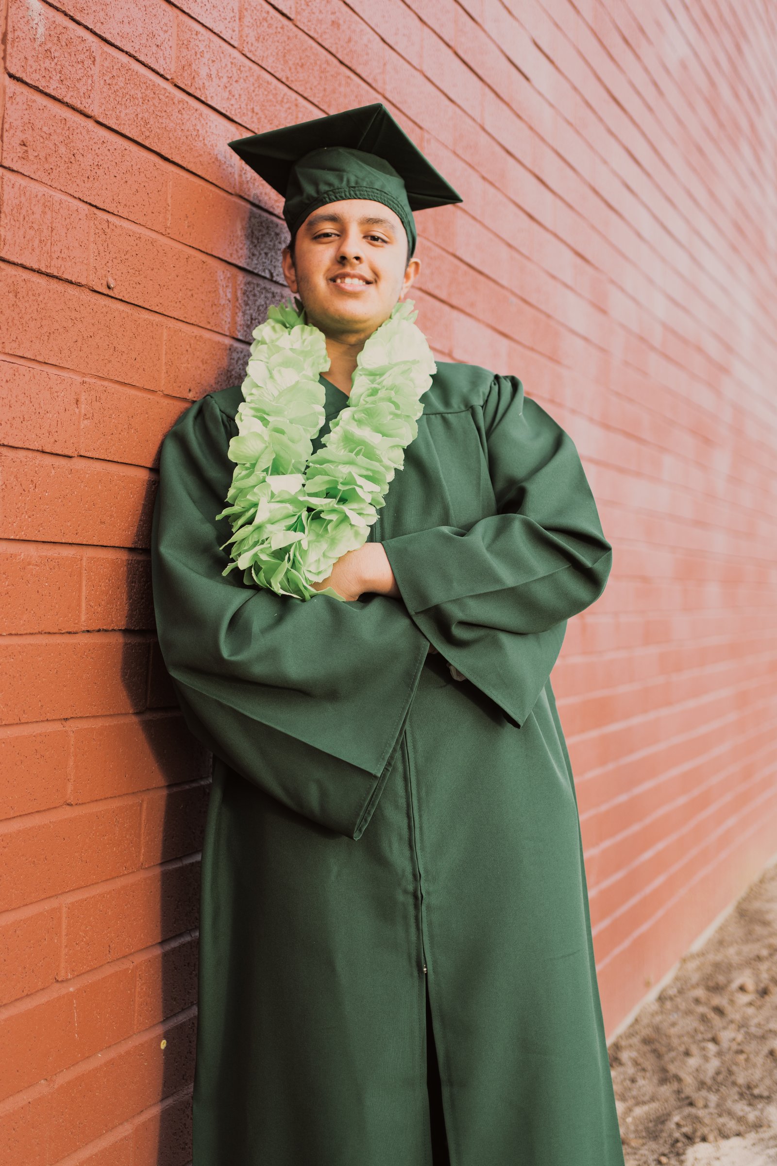 Robin's graduation 2022 cap and gown red brick wall